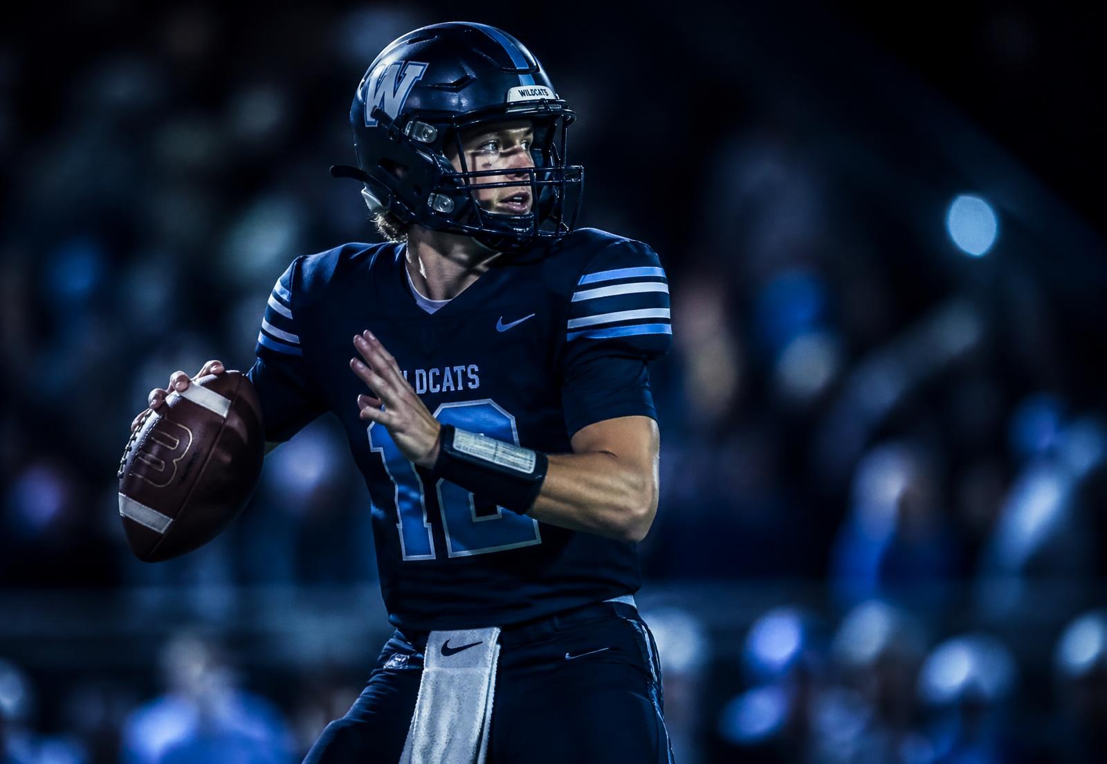 High school quarterback under stadium lights